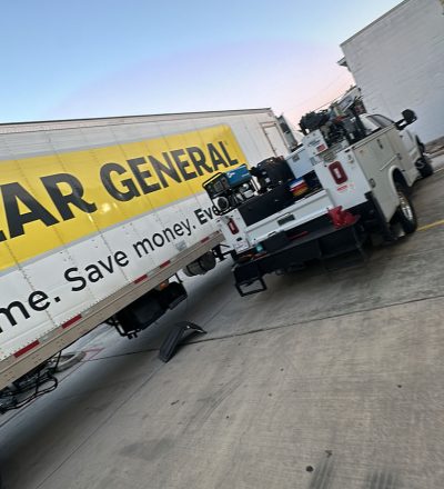 A truck with a yellow and black trailer parked on a road